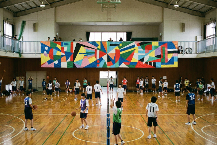 体育館のギャラリーに掲示された横断幕と部活動の練習風景
