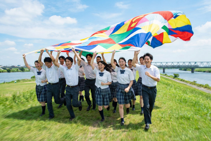 横断幕の前で笑顔を見せる部活動チームの集合写真