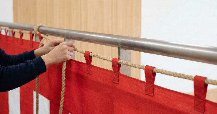 チチ（ひも通し）にひもを通し、フェンスや手すりにしっかり固定する手順